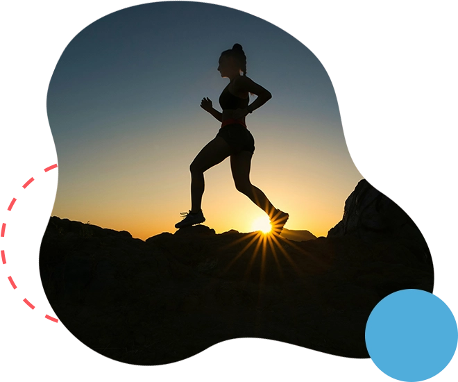 A woman running in the sunset on top of a hill.