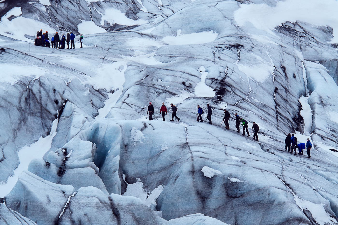 A group of people standing on top of a snow covered slope.